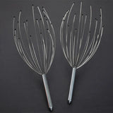 Two metal scalp massagers on a dark background