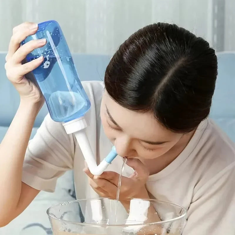 Person using a nasal irrigation device with a clear bowl below.
