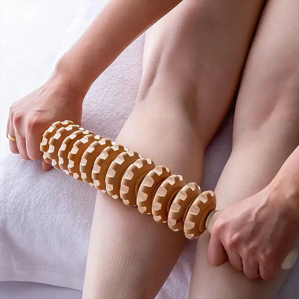 Person using a wooden massage roller on their leg